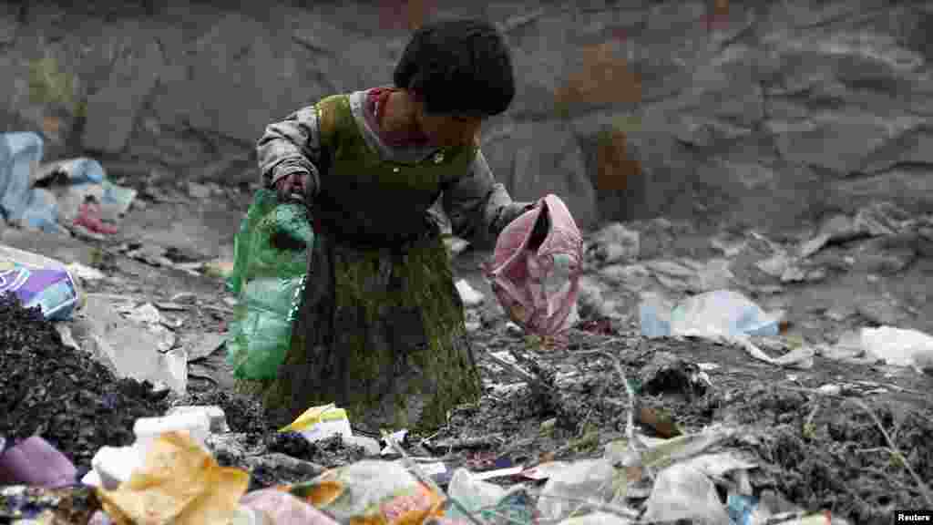 An Afghan girl searches for recyclable items at a rubbish heap on the outskirts of Kabul on April 26. (Reuters/Omar Sobhani)