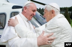 Папа Бэнэдыкт XVI, які сышоў у адстаўку, (зправа) разьвітваецца са сваім перамнікам папам Францыскам, 2013