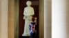 A boy stands in front of a statue of former British Prime Minister Margaret Thatcher on display in the Guildhall Art Gallery in London.