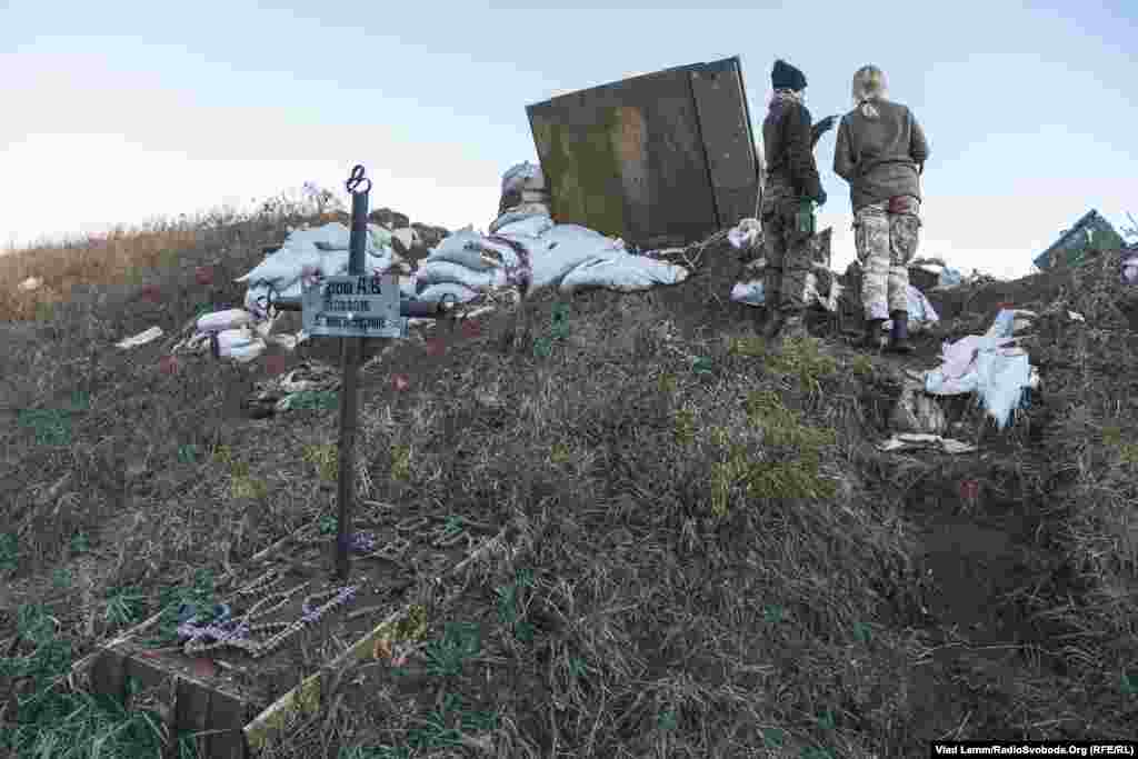 Могила українського військового, прикрашена гербом із гільз​