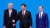 Czech President Milos Zeman (left), Chinese President Xi Jinping (center), and Russian Prime Minister Dmitry Medvedev (right) pose at the China International Import Expo in Shanghai.