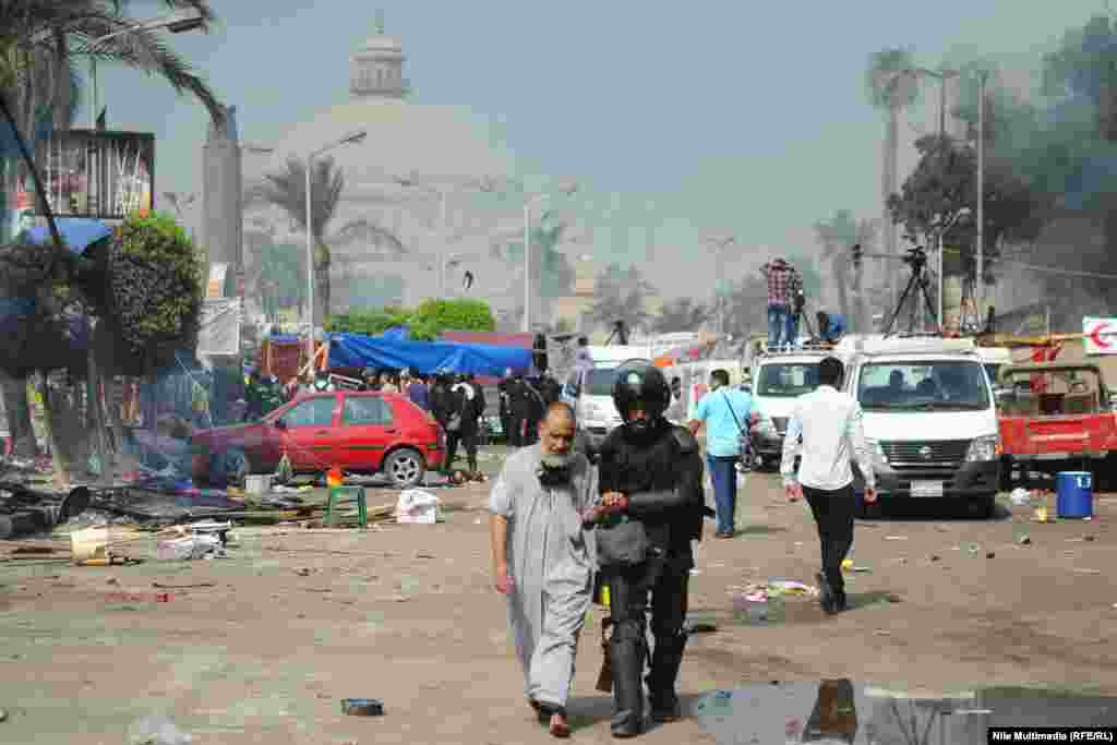 A police officer accompanies a supporter of Morsi as forces dispersed the protesters.