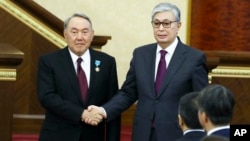 Сложивший полномочия первый президент Казахстана Нурсултан Назарбаев (слева) и принесший присягу президент Казахстана Касым-Жомарт Токаев пожимают друг другу руки. Астана, 20 марта 2019 года.