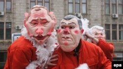 Западные аналитики полагают, что премьер Украины (маска справа) действует с подачи президента России (маска слева)