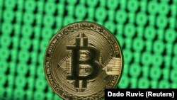 Un Bitcoin pe un ecran de computer