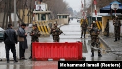 Afghan security forces keep watch at a check point near the site of a suicide attack in Kabul on February 24.