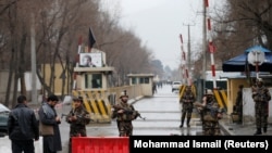 Afghan security forces keep watch at a check point near the site of a suicide attack in Kabul on February 24.