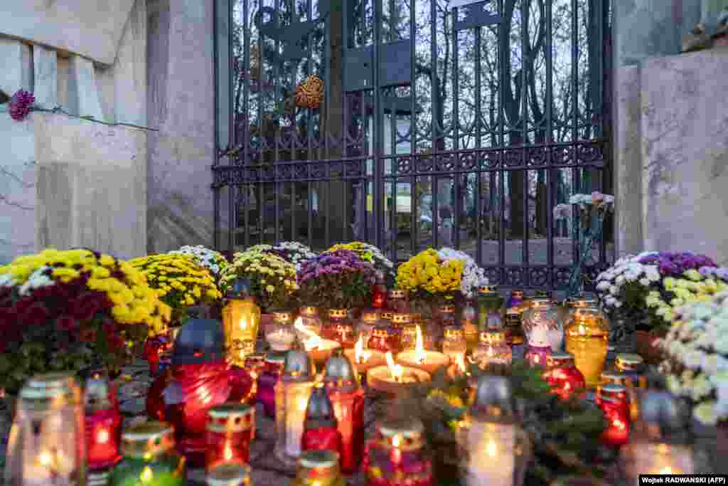 Candles and flowers are placed in front of the locked gate to Powazki cementary in Warsaw. The Polish government closed cemeteries due to the COVID-19 pandemic two days before All Saints&#39; Day.&nbsp;