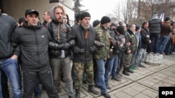Представители так называемой "крымской самообороны" охраняют подступы к зданию парламента Крыма весной 2014 года