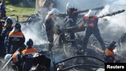Российские спасатели выносят обгоревшие тела из-под завалов интерната. Новгородская область, 13 сентября 2013 года.