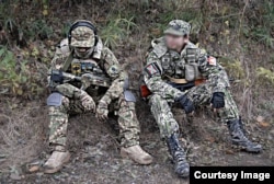 Japanese airsoft players wearing opposing badges of Ukraine’s Azov battalion (left) and Russia-backed separatists.