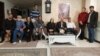 Family and friends of Pooya Bakhtiari. Father and mother sitting on right side sofa, father in white shirt. Grandfather in blue-striped shirt (L). Undated