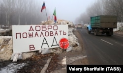 "Isten hozott a Pokolban!" egy ellenőrzőpont felirata az ukránul Gorlivkának, oroszul Gorlovkának nevezett település bejáratánál, felette az orosz és egy szeparatista zászlóval, 2014. december 14-én.
