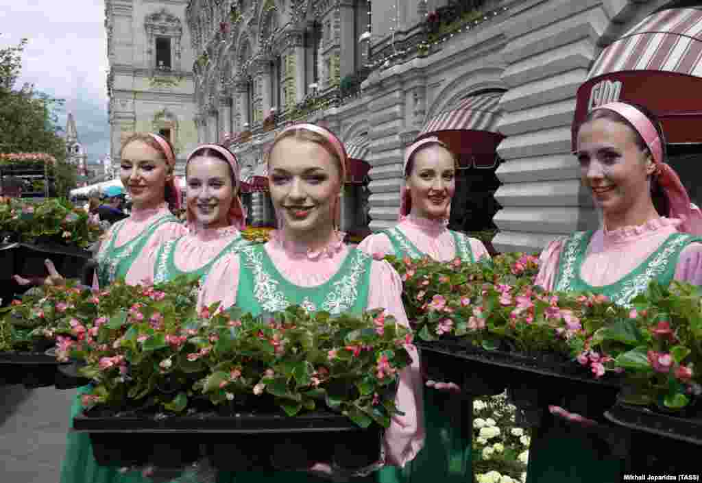 Women dressed in traditional clothing pose during the annual Flower Festival at the GUM department store in Moscow. (TASS/Mikhail Japaridze)