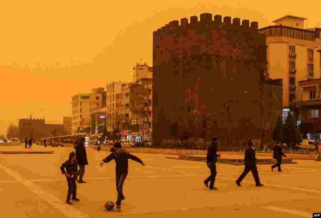 Boys play football during a dust storm in the Turkish town of Diyarbakir on April 9. (AFP/Ilyas Akengin) 