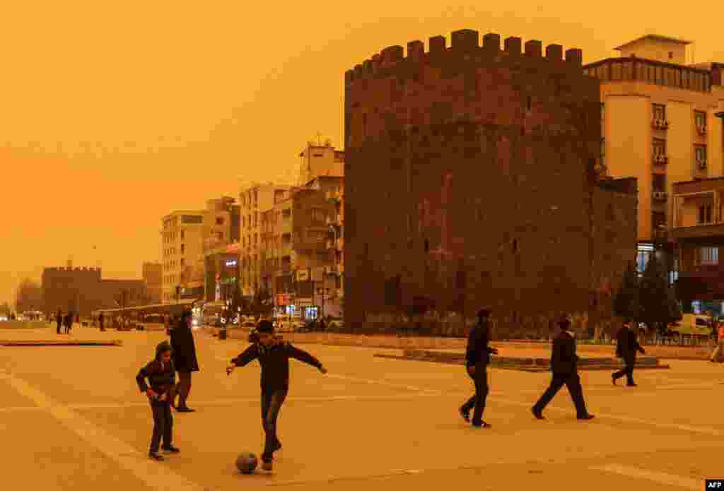 Boys play football during a dust storm in the Turkish town of Diyarbakir on April 9. (AFP/Ilyas Akengin)&nbsp;