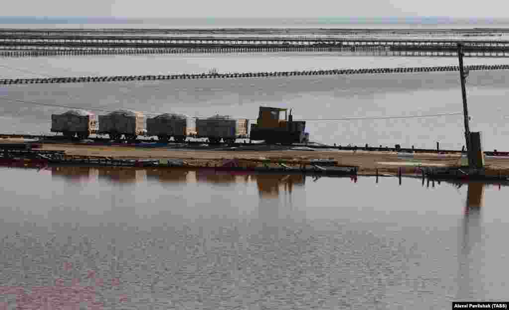 Мініатюрний потяг везе сіль уздовж берега озера.