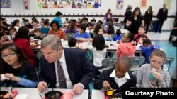 Том Вилсак и Мишель Обама (на заднем плане) за ланчем в начальной школе Парклаун (Александрия, Вирджиния) в ходе кампании за здоровую пищу для детей.