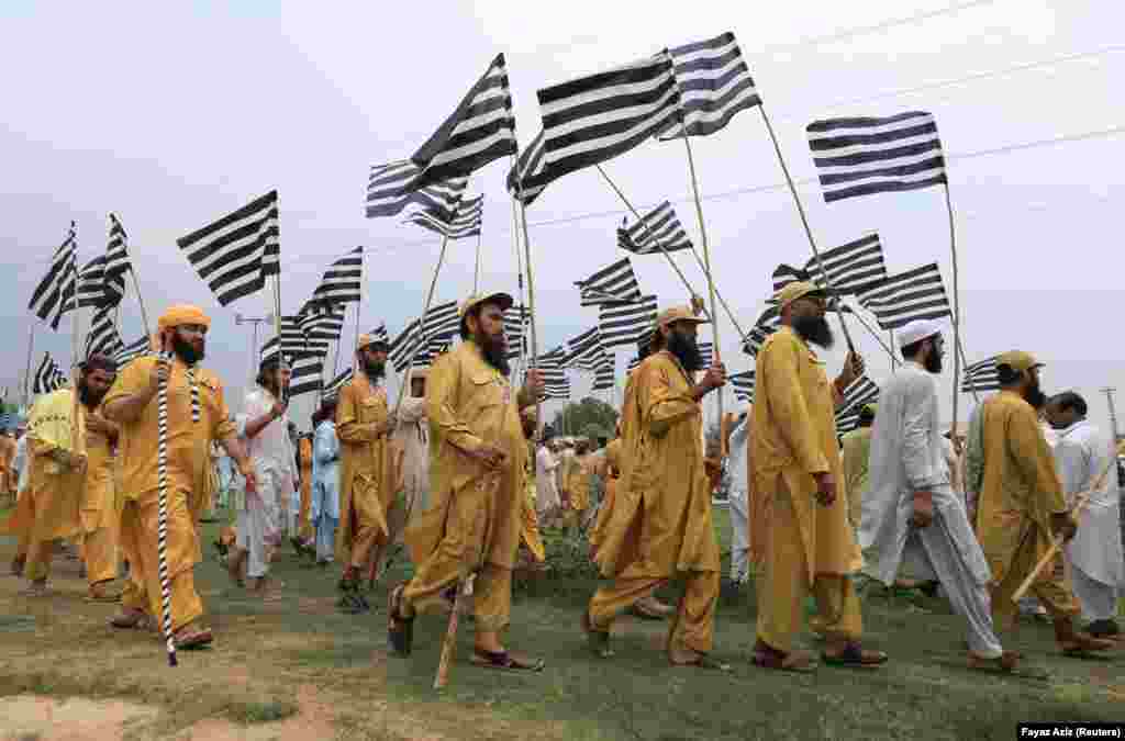 Supporters of Pakistani opposition political parties walk with flags during a countrywide protest called "Black Day" against the government of Prime Minister Imran Khan in Peshawar on July 25. (Reuters/Fayaz Aziz)