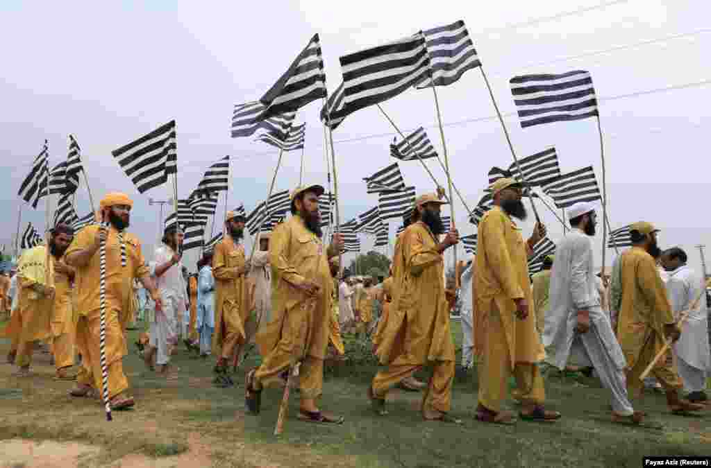 Supporters of Pakistani opposition political parties walk with flags during a countrywide protest called &quot;Black Day&quot; against the government of Prime Minister Imran Khan in Peshawar on July 25. (Reuters/Fayaz Aziz)