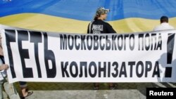 Protesters from a nationalist party lay out a flag of Ukraine to protest against a visit by Patriarch Kirill in Kyiv on July 27.