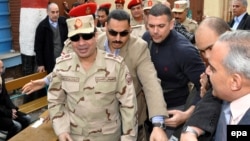 سیسی -در جلوی تصویر- در زمان رای‌گیری همه‌پرسی قانون اساسی مصر