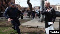 Armenia - A policeman rushes to stop a man from setting himself on fire, Yerevan, 7Mar2014.