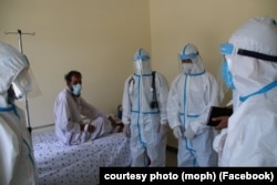 A patient with coronavirus is attended to by medical personnel in Afghanistan's Laghman Province.