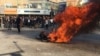 Iranian protesters gather around a burning motorcycle most probably belonging to anti-riot police, during protests in the central city of Isfahan, on November 16, 2019