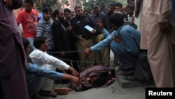 شرطة باكستانيون يجمعون الأدلة الجنائية في حادث قتل (فرزانه بارفين) التي قتلت رجماً من قبل أفراد عائلتها.