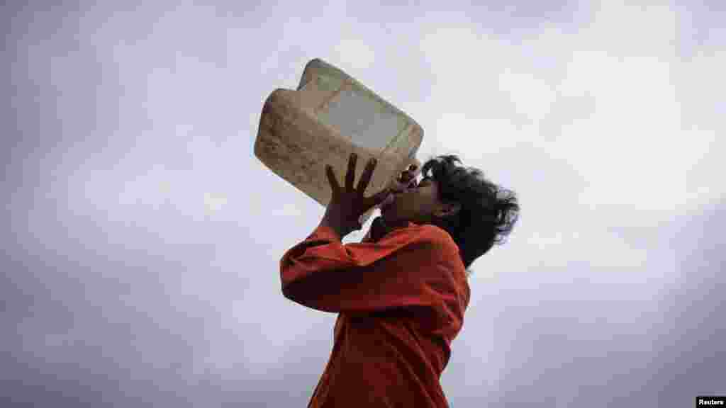 A boy drinks water from a plastic container in Karachi, Pakistan.