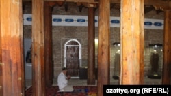 Мужчина во время молитвы на территории государственного историко-культурного музея-заповедника «Азрет Султан», включающего мавзолей Ходжи Ахмета Яссауи.