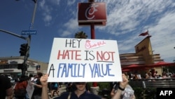 An gay rights protestor holds a sign outside a Chick-fil-A fast food restaurant, in Hollywood, California.