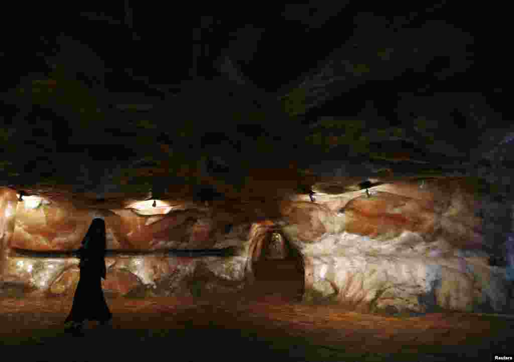 A woman dressed in a black burqa walks through the salt mines of Khewra.