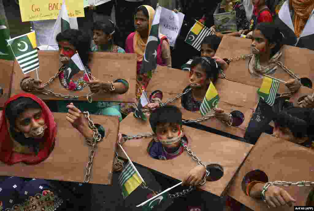 Children hold Kashmiri and Pakistani flags as they take part in an anti-Indian protest in Lahore. (AFP/Arif Ali)