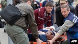 Людзі дапамагаюць ахвяры выбуху ў менскім мэтро, 11 красавіка 2011