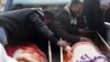 Residents mourn over coffins containing the victims of a December bomb attack in Al-Fallujah, Iraq.