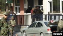 A soldier stands guard at the entrance of the military quarters of the War Academies while police search the residence of a retired army general in Istanbul.
