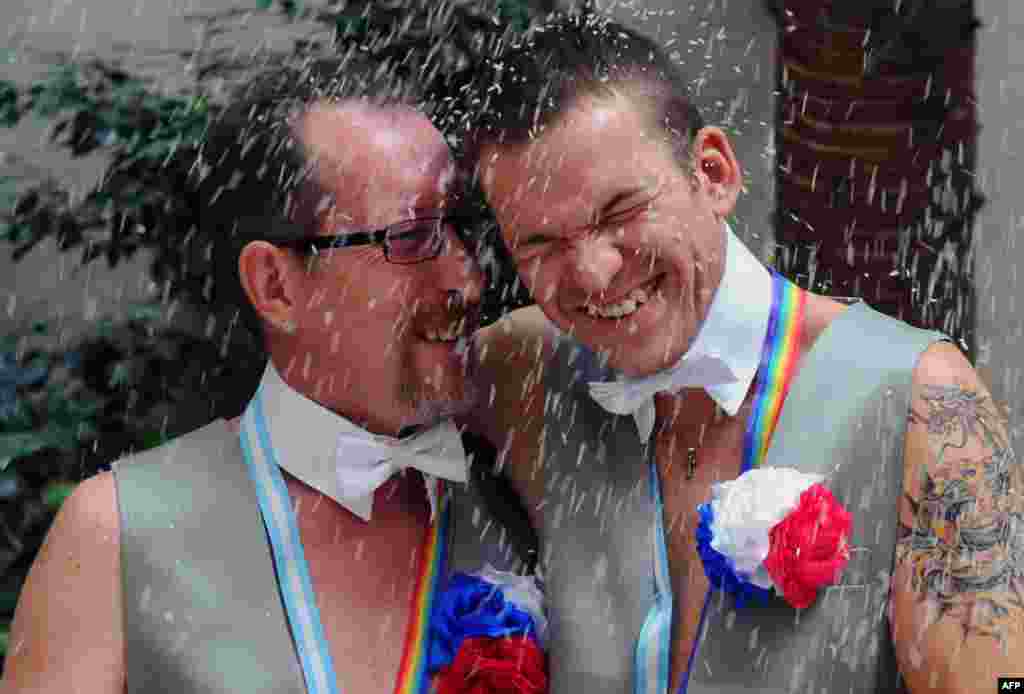 Russians Aleksandr Emereev (left) and Dmitry Zaytsev smile after getting married in Buenos Aires, Argentina, on February 25. Same-sex couples are not able to marry in Russia, and gay Russians have faced growing levels of repression and violence. (Daniel Garcia, AFP)