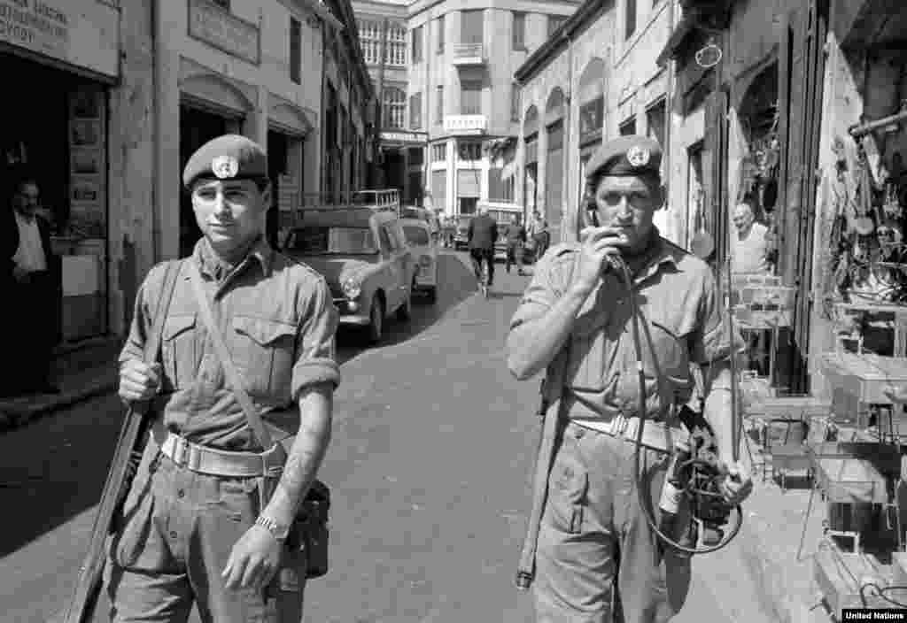 Two UN soldiers patrol a shopping area of the Cypriot capital, Nicosia, in April 1964. UN troops were deployed on the island to prevent intercommunal violence between ethnic Greek and Turkish Cypriots. 