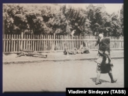 На фото жінки проходять повз помираючих від голоду людей, Харків, 1933 рік (фото австрійського інженера Александра Вінербергера)