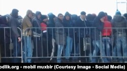 Трудовые мигранты стоят в очереди в миграционном центре в Сахарове.