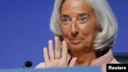 International Monetary Fund (IMF) Managing Director Christine Lagarde waves as she arrives to address the plenary session at the start of the annual IMF and World Bank fall meetings in Washington on October 11.