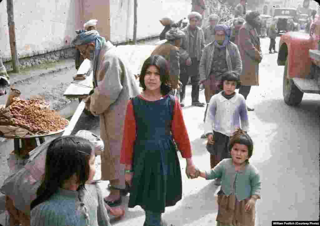 Two sisters pose for a photograph on a street in Kabul.