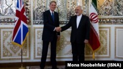 U.K. Foreign Secretary Philip Hammond (left) meets his Iranian counterpart Mohammad Javad Zarif in Tehran on August 23. 
