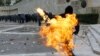 A Greek protester in Athens throws a petrol bomb at riot police during demonstrations on December 6 to mark the 2008 shooting of a student by police. (Photo for Reuters by Yannis Behrakis)
