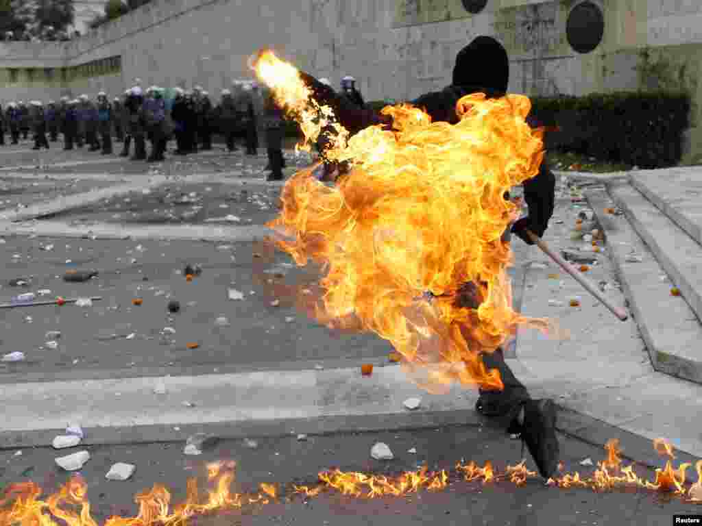 A Greek protester in Athens throws a petrol bomb at riot police during demonstrations on December 6 to mark the 2008 shooting of a student by police. (Photo for Reuters by Yannis Behrakis)