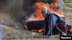 Газа қаласының шығыс бөлігінде Израиль әскерилерімен қақтығыс болып жатқан жерде жүрген палестиналық. 15 желтоқсан 2017 жыл.