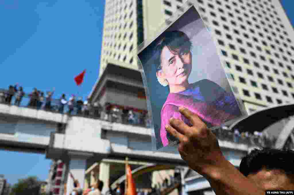 Një protestues mban në dorë një foto të udhëheqëses së rrëzuar Aung San Suu Kyi ndërsa protestuesit mblidhen për të demonstruar kundër grushtit të shtetit ushtarak të 1 Shkurtit, Yangon, 8 Shkurt 2021. (Ye Aung Thu/AFP)