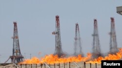 Flames emerge from burning excess gas and oil at Rumaila oilfield in Basra, May 11, 2017
